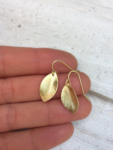 Brushed leaf earring gold in hand