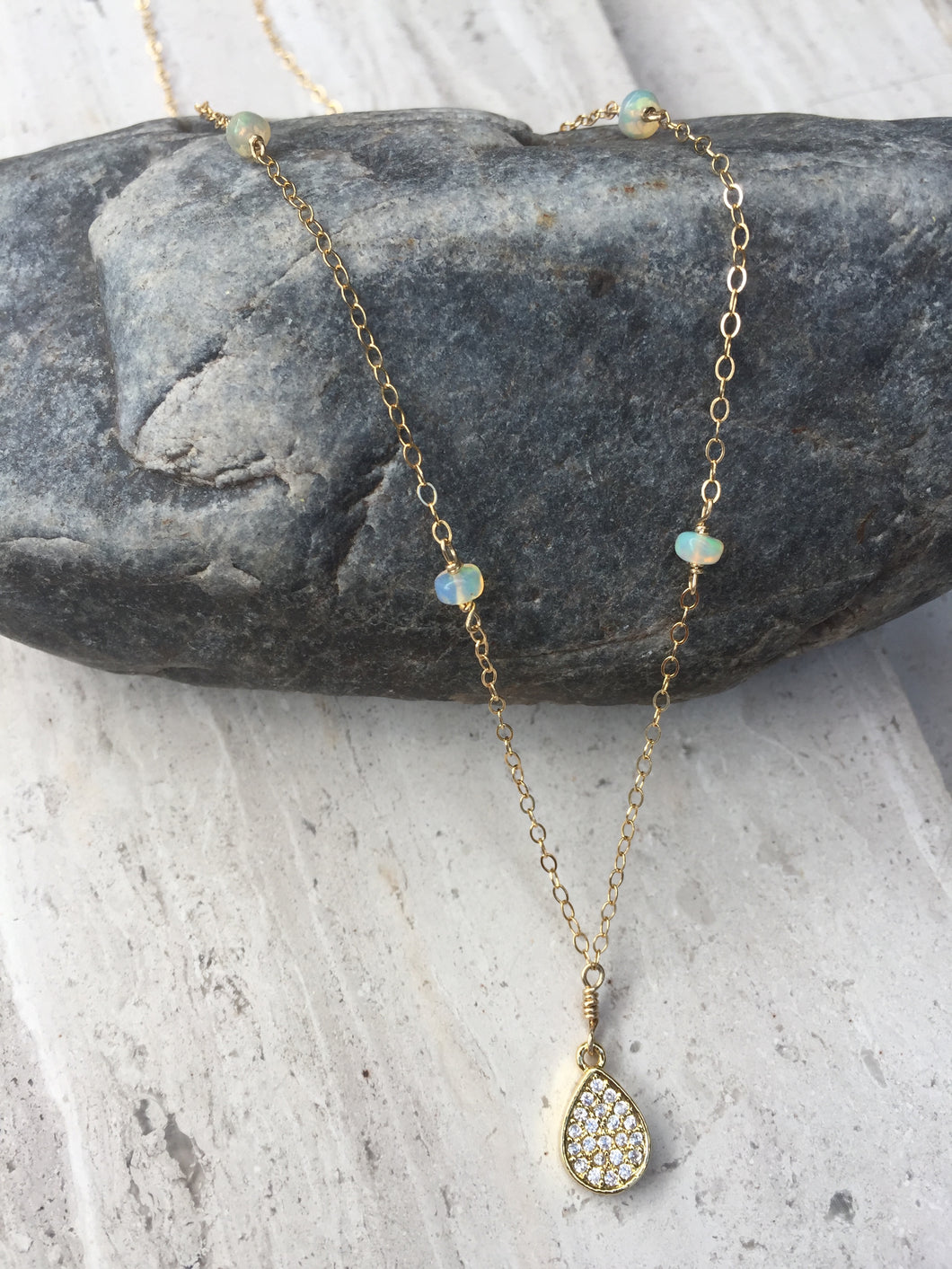 Opal and CZ Drop Necklace on rock