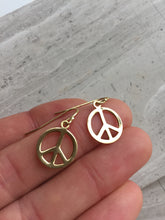 Peace sign earrings, gold, in hand